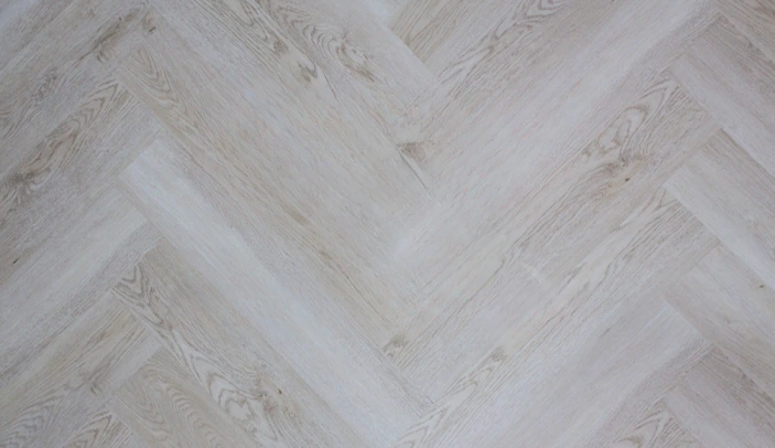 Light herringbone SPC flooring with subtle wood texture