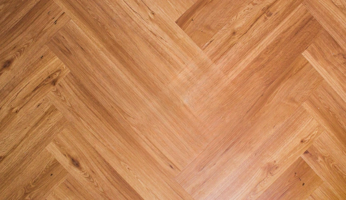 Warm herringbone SPC flooring with knotty wood texture
